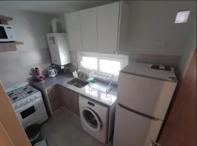 a small kitchen with a refrigerator and a dishwasher at Apart Center in Río Cuarto