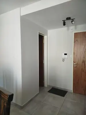 a room with a white wall and a door at Apart Center in Río Cuarto