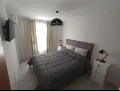 a bedroom with a large bed and a pendant light at Apart Center in Río Cuarto