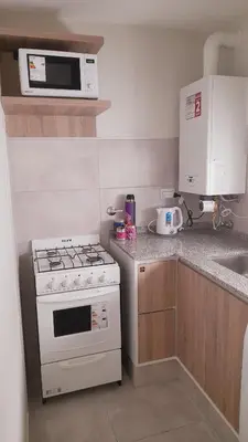 a kitchen with a stove and a microwave at Apart Center in Río Cuarto
