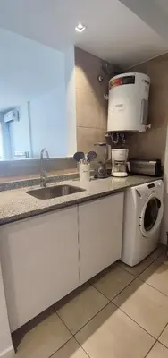 a kitchen with a sink and a washing machine at Rincón Córdoba in Cordoba