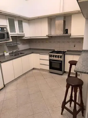 a kitchen with a stove and two stools in it at Casa Cento in Santa Rosa de Calamuchita