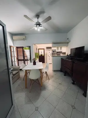 a living room with a table and a kitchen at Casa Cento in Santa Rosa de Calamuchita