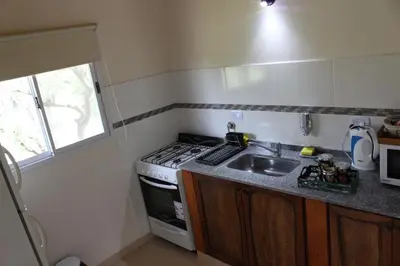 a small kitchen with a stove and a sink at Amaneciendo cabañas in Merlo