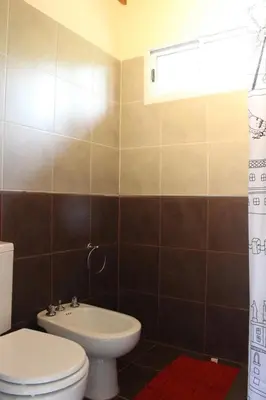 a bathroom with a toilet and a sink at Amaneciendo cabañas in Merlo