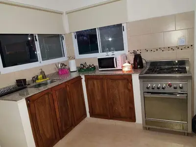 a kitchen with wooden cabinets and a stove top oven at Amaneciendo cabañas in Merlo
