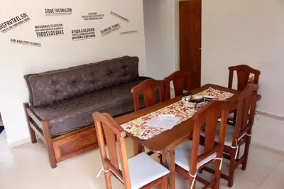 a dining room with a couch and a table and chairs at Amaneciendo cabañas in Merlo