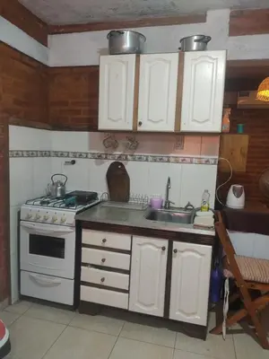 a kitchen with white cabinets and a stove and a sink at Don Sabino in Arroyo de Los Patos