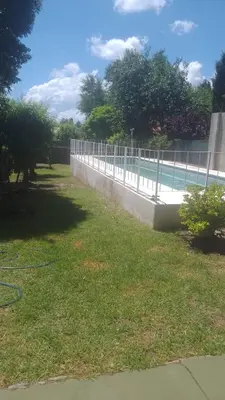 a fence next to a swimming pool in a yard at Casa centrica con Piscina in Mina Clavero