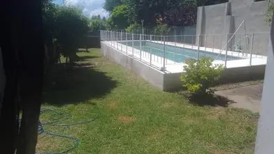 a swimming pool with a hose in the grass at Casa centrica con Piscina in Mina Clavero