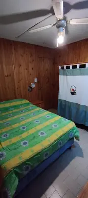 a bedroom with a bed with a green comforter at Casa centrica con Piscina in Mina Clavero