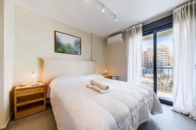 a bedroom with a large white bed and a window at Av Velez Sarsfield B Nueva Córdoba in Cordoba
