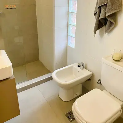 a white bathroom with a toilet and a shower at Av Velez Sarsfield B Nueva Córdoba in Cordoba