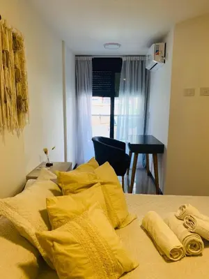a bed with yellow pillows on top of it at Av Estrada 48 B Nueva Córdoba in Cordoba