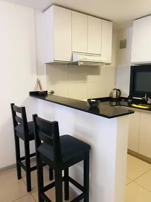 a kitchen with two chairs and a counter in a kitchen at Av Estrada 48 B Nueva Córdoba in Cordoba