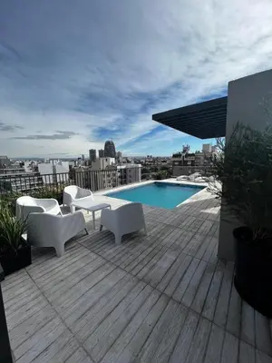 a patio with white chairs and a pool on a building at Lima 1300 B General Paz in Cordoba