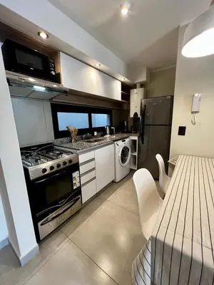 a kitchen with a stove and a sink and a microwave at Lima 1300 B General Paz in Cordoba