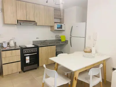 a kitchen with a white table and a refrigerator at Arturo M Bas B Güemes in Cordoba