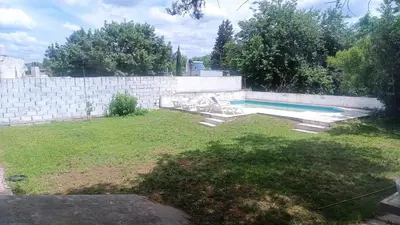 a backyard with a swimming pool and a wall at Casa Ayeya in Villa Carlos Paz