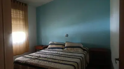 a bedroom with a bed with a blue wall at Casa Ayeya in Villa Carlos Paz