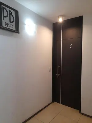 a black door in a room with a sign on the wall at Departamento a metros peatonal Carlos Paz in Villa Carlos Paz