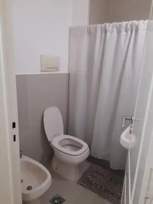 a white bathroom with a toilet and a sink at Departamento a metros peatonal Carlos Paz in Villa Carlos Paz