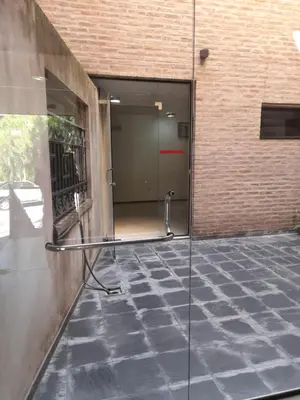 a glass door of a building with a walk in shower at Departamento a metros peatonal Carlos Paz in Villa Carlos Paz