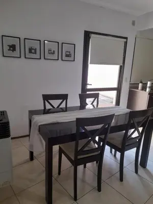 a dining room with a table and chairs and a window at Departamento a metros peatonal Carlos Paz in Villa Carlos Paz