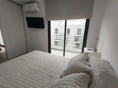 a bedroom with a bed and a large window at Sam 1 Sampaoli in Villa Carlos Paz