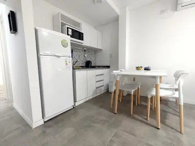 a kitchen with a white refrigerator and a table at Sam 1 Sampaoli in Villa Carlos Paz