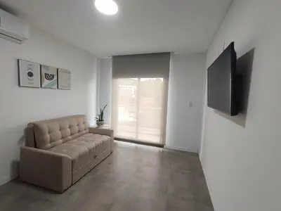 a living room with a couch and a flat screen tv at Sam 1 Sampaoli in Villa Carlos Paz