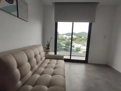 a living room with a couch and a large window at Sam 1 Sampaoli in Villa Carlos Paz