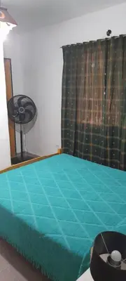 a bedroom with a bed with a green comforter at Todo cerca in Mina Clavero