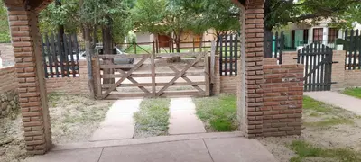 an archway with a gate with a fence and a dog at Todo cerca in Mina Clavero