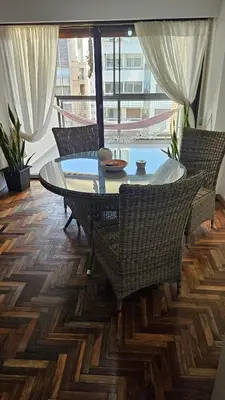 a dining room with a glass table and wicker chairs at Apartamento en Nueva Córdoba in Cordoba