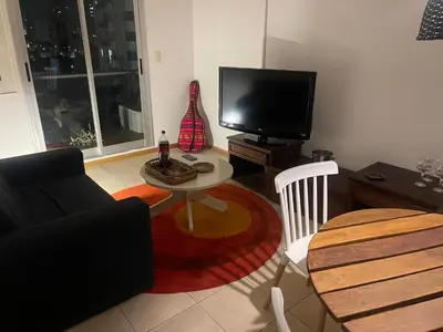 a living room with a couch and a table and a tv at Cielos de Güemes in Cordoba