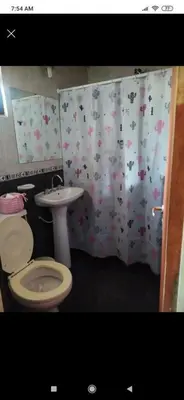 a bathroom with a toilet and a shower curtain with cows at Cabaña con piscina compartida in Mina Clavero
