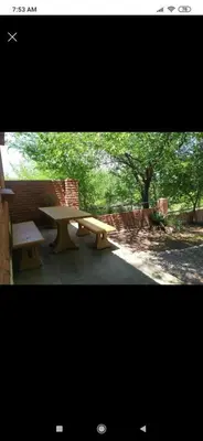 a picnic table and a bench in a park at Cabaña con piscina compartida in Mina Clavero