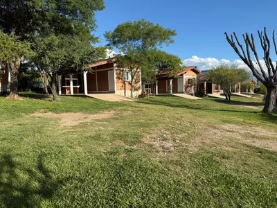a yard with a house in the background at Cabañas AdamiS 2 in Villa Cura Brochero