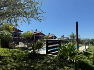 a house with a pool and a playground at Cabañas AdamiS 2 in Villa Cura Brochero