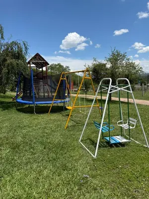 a group of playground equipment in a park at Cabañas AdamiS 2 in Villa Cura Brochero