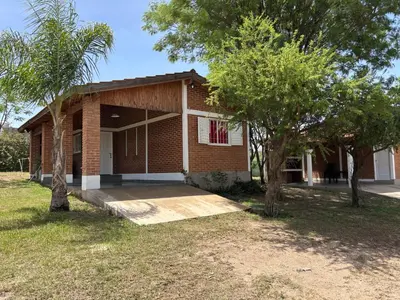 a brick house with trees in front of it at Cabañas AdamiS 2 in Villa Cura Brochero