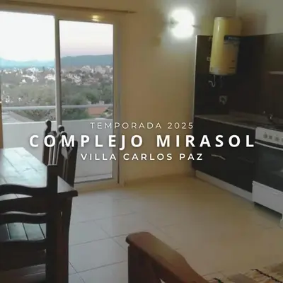 a kitchen with a table and a large window at Complejo Mirasol en Carlos Paz in Villa Carlos Paz