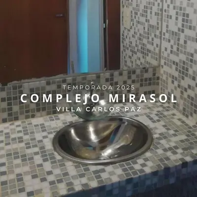 a bathroom with a metal toilet in a tiled floor at Complejo Mirasol en Carlos Paz in Villa Carlos Paz