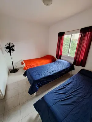 a bedroom with two beds and a window at Duplex en complejo in Villa Carlos Paz