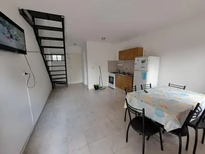 a kitchen and dining room with a table and a refrigerator at Duplex en complejo in Villa Carlos Paz