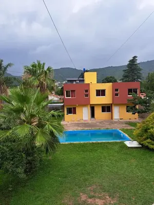a house with a swimming pool in front of it at Duplex en complejo in Villa Carlos Paz