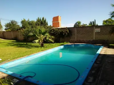 a large blue swimming pool in a yard at Duplex en complejo in Villa Carlos Paz
