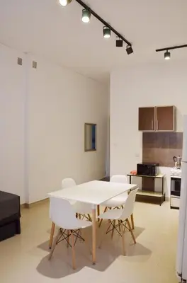 a dining room with a white table and white chairs at Amplio departamento de un dormitorio a 15 min del centro de la ciudad in Cordoba