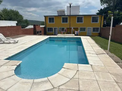 a large swimming pool in front of a house at A carlos paz voy in Villa Carlos Paz